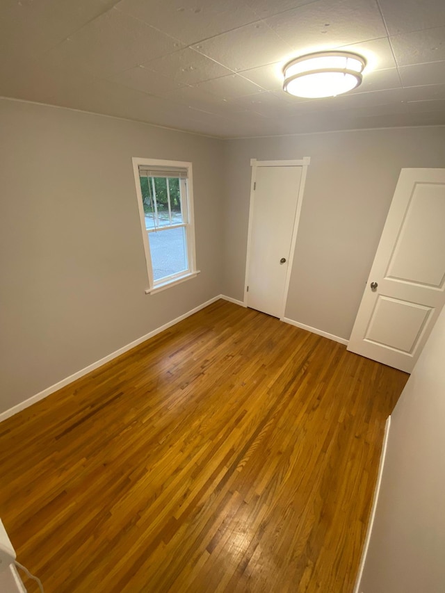 unfurnished room with baseboards and wood finished floors