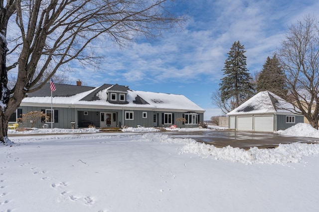 view of front of house with board and batten siding, a detached garage, and an outdoor structure