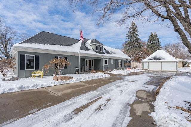 view of front of home with board and batten siding, a detached garage, and an outdoor structure