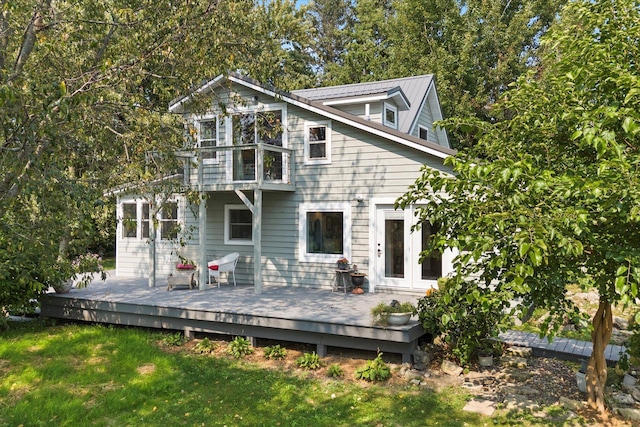 back of property featuring a lawn and a wooden deck