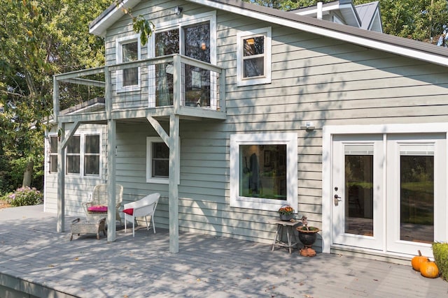 back of house with french doors, a balcony, and a deck