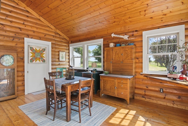 dining space featuring log walls, light wood finished floors, wood ceiling, and vaulted ceiling