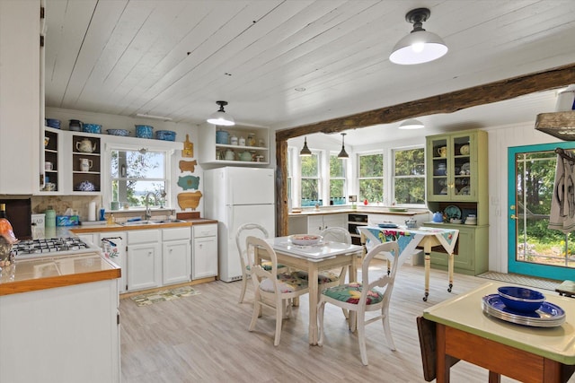 kitchen featuring open shelves, wood counters, a sink, freestanding refrigerator, and white cabinets