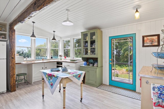 interior space featuring light wood-type flooring and vaulted ceiling with beams