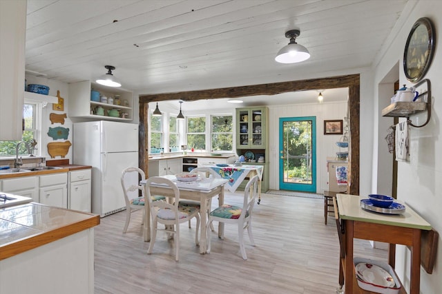 dining space featuring light wood-style flooring and wooden ceiling