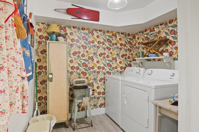 washroom with wallpapered walls, baseboards, laundry area, light wood-style flooring, and independent washer and dryer