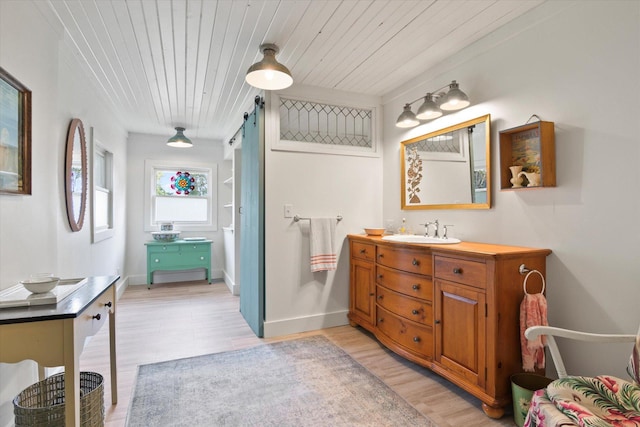 bathroom with baseboards, wood finished floors, wooden ceiling, and vanity