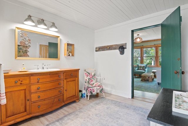 bathroom featuring vanity, wood ceiling, and wood finished floors