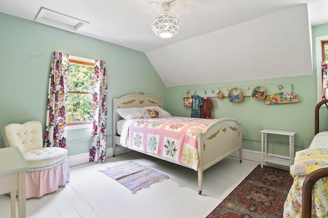 bedroom with attic access, wood finished floors, baseboards, and lofted ceiling