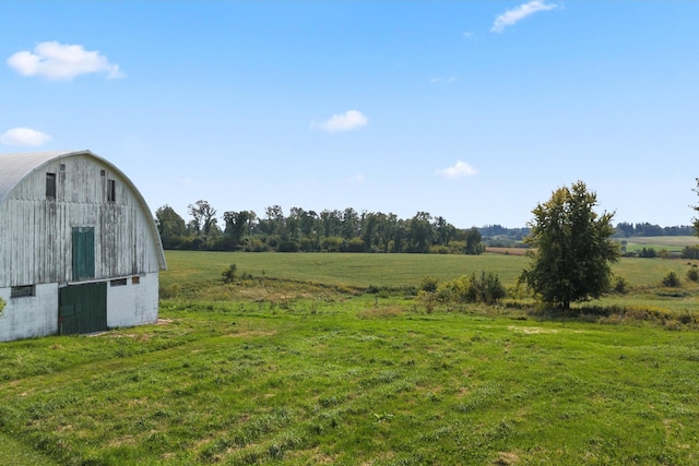 view of yard with an outbuilding, a rural view, and a barn