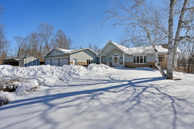 view of front of property with a storage shed, a garage, an outbuilding, and brick siding