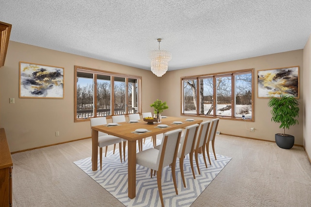 dining area featuring light carpet, a chandelier, a textured ceiling, and baseboards