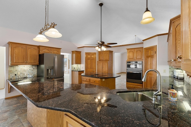 kitchen with a peninsula, stainless steel fridge with ice dispenser, a sink, double oven, and tasteful backsplash