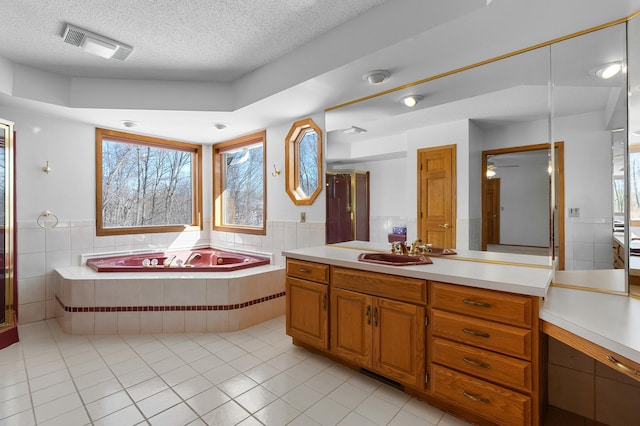 full bath featuring a garden tub, visible vents, a wealth of natural light, and a textured ceiling