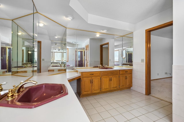 bathroom featuring tile patterned flooring, a wainscoted wall, two vanities, and a sink