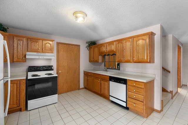 kitchen featuring under cabinet range hood, light countertops, brown cabinetry, white appliances, and a sink