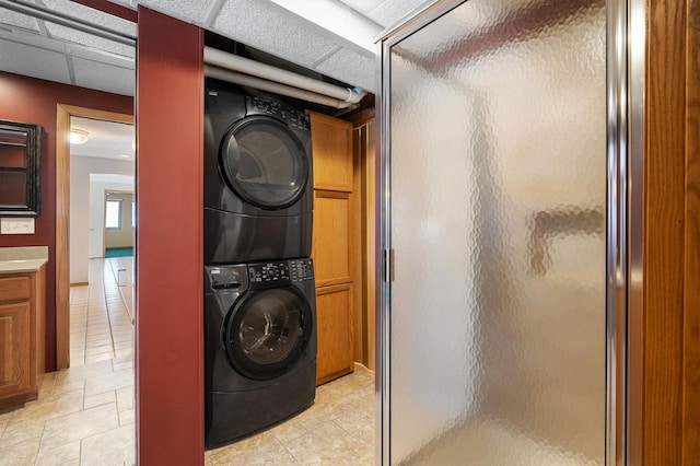 washroom with cabinet space and stacked washer / drying machine