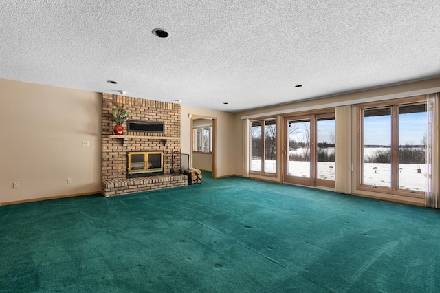 unfurnished living room with carpet flooring, baseboards, a textured ceiling, and a fireplace