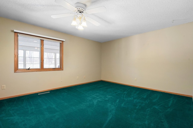 empty room with visible vents, carpet floors, a textured ceiling, and baseboards