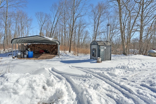 snowy yard featuring a detached carport