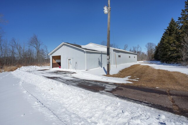 view of snow covered exterior with an outdoor structure and a garage