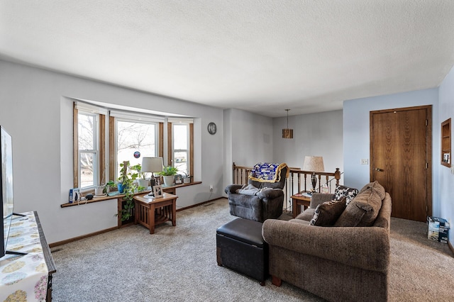 carpeted living room with a textured ceiling and baseboards