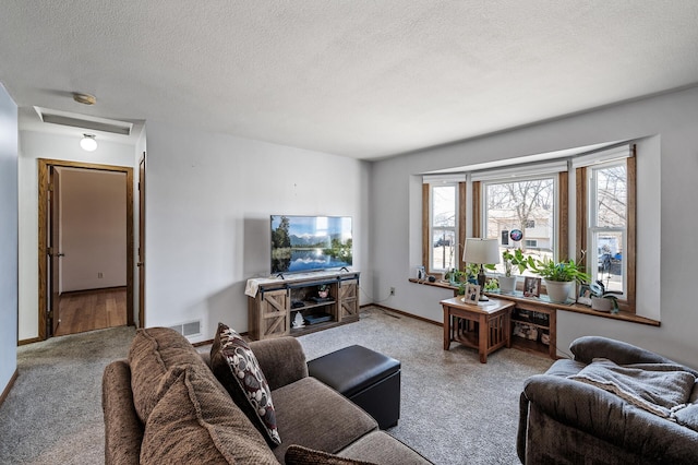 carpeted living area featuring visible vents, baseboards, and a textured ceiling