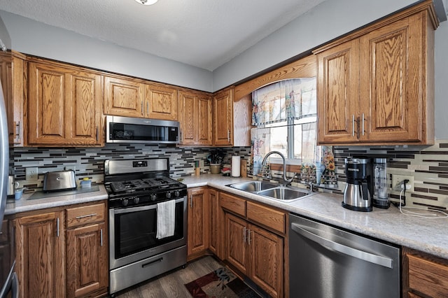 kitchen featuring a sink, brown cabinetry, and stainless steel appliances