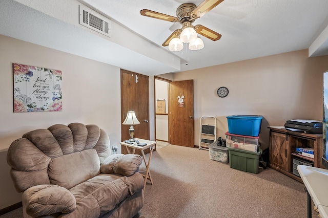 living room featuring carpet flooring, visible vents, and ceiling fan