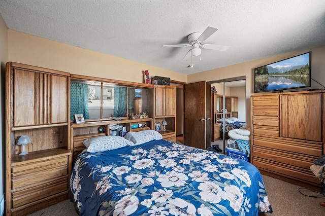 carpeted bedroom featuring ceiling fan, a closet, and a textured ceiling