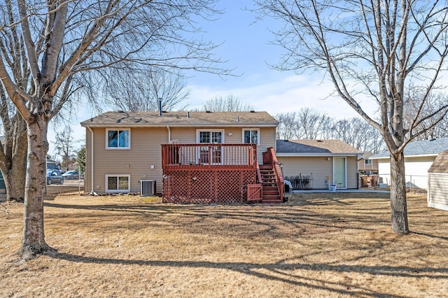 rear view of property featuring central air condition unit, a lawn, a wooden deck, and stairway