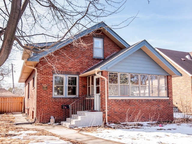 bungalow-style home with brick siding and fence