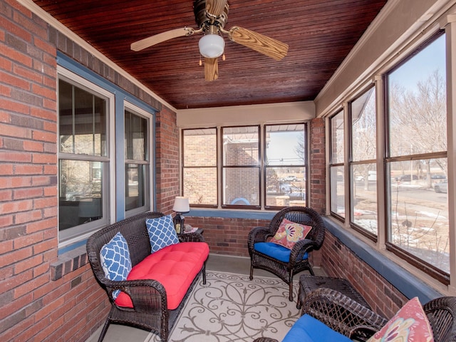 sunroom with a wealth of natural light, wood ceiling, and a ceiling fan