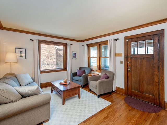 living area with light wood finished floors, crown molding, and baseboards