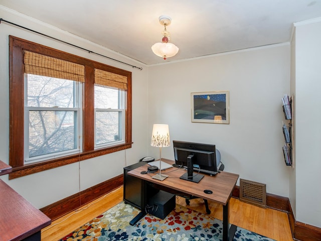 office with crown molding, wood finished floors, baseboards, and visible vents