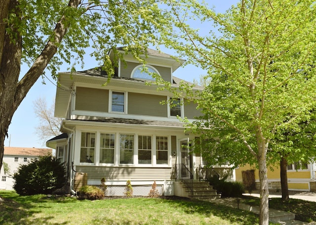 american foursquare style home featuring a front yard