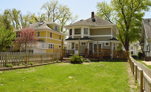 rear view of property with a wooden deck and a chimney