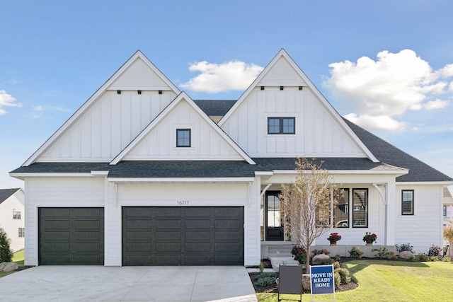 modern inspired farmhouse featuring a front yard, board and batten siding, driveway, and roof with shingles