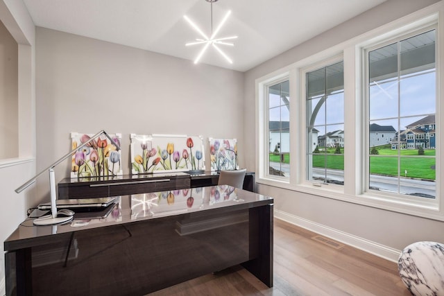 interior space featuring a chandelier, visible vents, baseboards, and wood finished floors