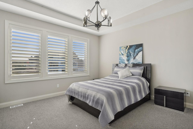 carpeted bedroom featuring a chandelier, visible vents, a raised ceiling, and baseboards