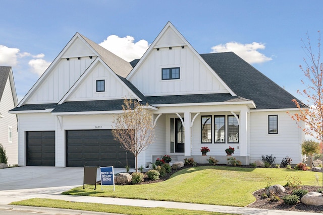 modern farmhouse with a garage, board and batten siding, driveway, and a front lawn