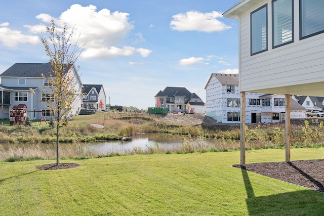 view of yard with a residential view and a water view