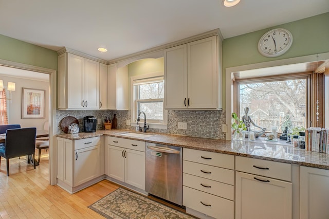 5920 Colfax Ave S, Minneapolis, MN 55419 - kitchen featuring stainless steel dishwasher, a sink, backsplash, light wood finished floors, and light stone countertops