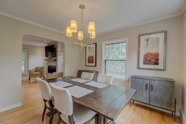 5920 Colfax Ave S, Minneapolis, MN 55419 - dining area featuring a fireplace, light wood finished floors, ornamental molding, baseboards, and arched walkways