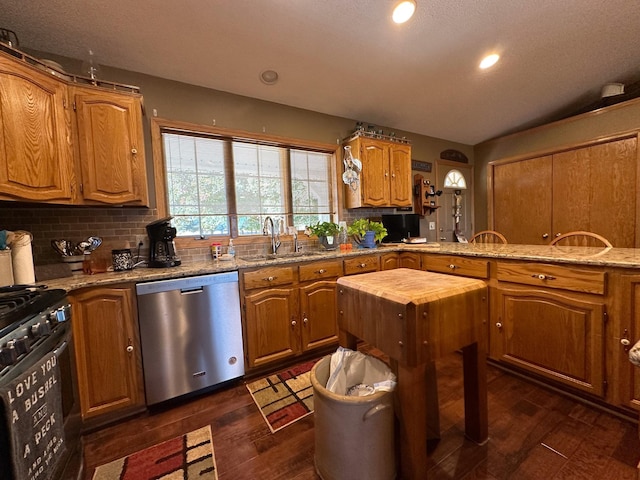 kitchen featuring stainless steel dishwasher, dark wood-style floors, backsplash, and a sink