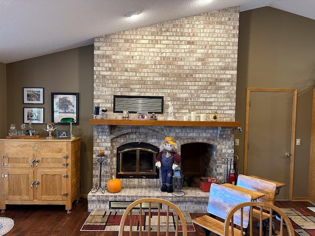 living room featuring dark wood-style floors, a brick fireplace, and vaulted ceiling