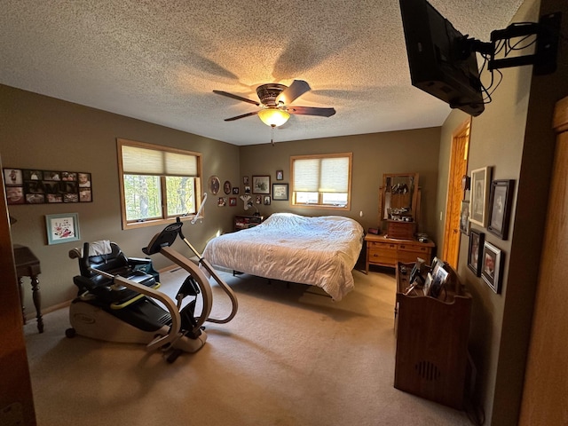 bedroom with light colored carpet, a textured ceiling, and a ceiling fan