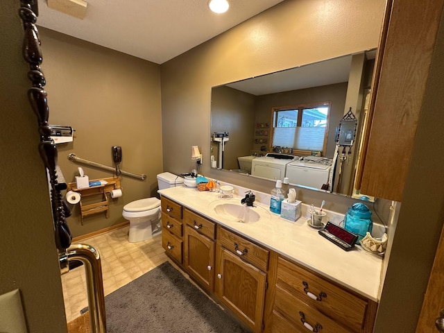 bathroom with independent washer and dryer, toilet, and vanity