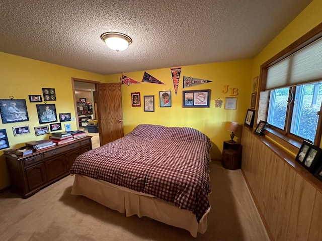 bedroom featuring light colored carpet and a textured ceiling