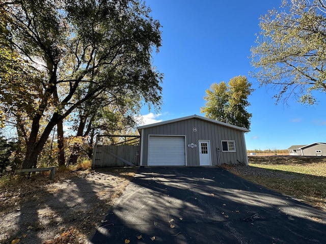 garage with aphalt driveway and fence